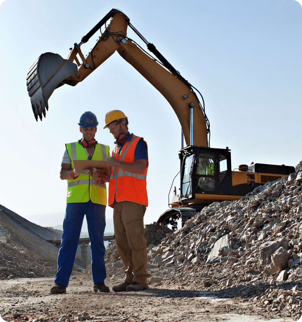 Site workers discussing project near excavator